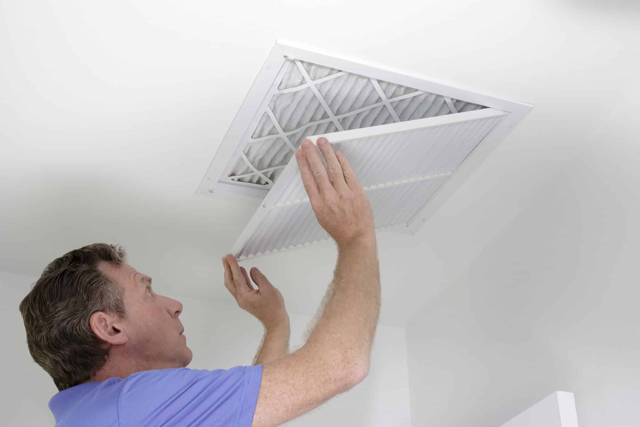 HVAC Strategies, A Man Closing a Grill After Replacing an Air Filter.