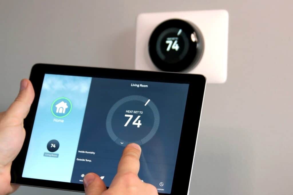 HVAC Efficiency: A man adjusting the temperature via a smart home app on a tablet in a modern living room.