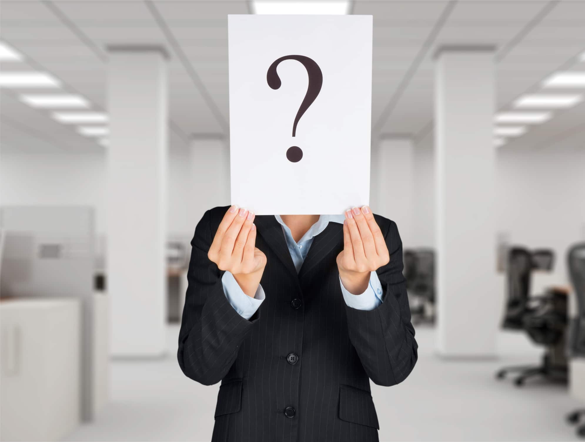 Businessman holding paper with question marks in front of face, Chilled Beam Retrofits.